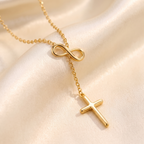 Collar de Cruz y Lazo Infinito en acero inoxidable, estilo lariat – detalle macro sobre satén