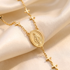 Collar Rosario en Y dorado con crucecitas y medalla de la Virgen Milagrosa – detalle macro sobre satén