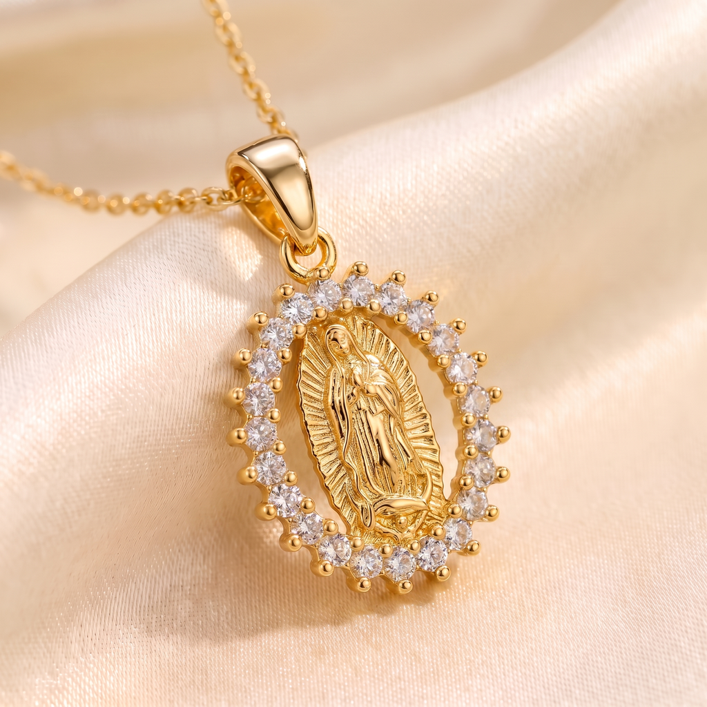 Collar Virgen de Guadalupe, medalla ovalada dorada con marco de circonias blancas – detalle macro sobre satén