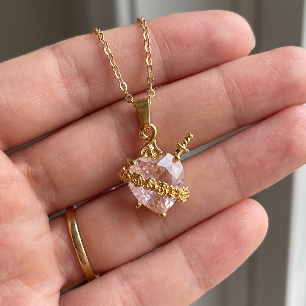 Collar del Inmaculado Corazón de María con cristal rosa en forma de corazón, espada dorada y rosas – escala real en la mano