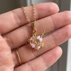 Collar del Inmaculado Corazón de María con cristal rosa en forma de corazón, espada dorada y rosas – escala real en la mano
