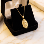 Collar Virgen de Guadalupe en forma de gota, relieve dorado con borde de rayos – en caja de terciopelo