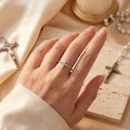 Anillo de cruz con circonias en plata, puesto en la mano
