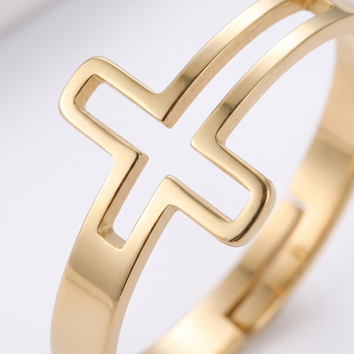 Detalle de la cruz vazada minimalista en dorado