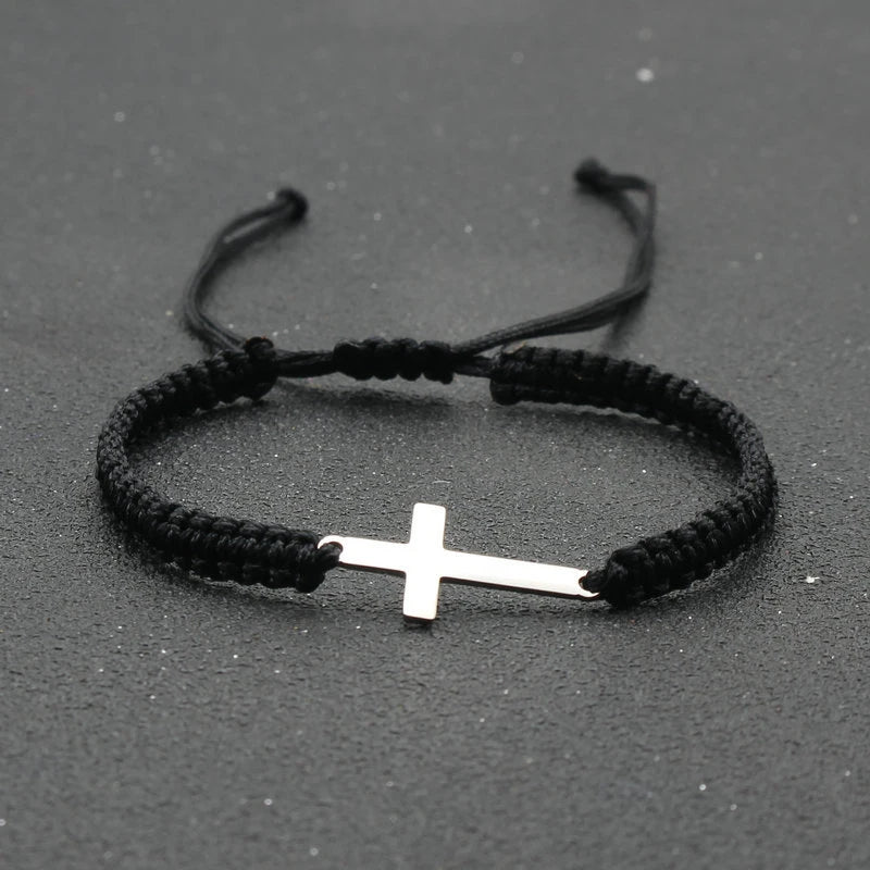 Pulsera de Cuerda con Cruz · Acero Inoxidable sobre superficie de madera — presentacion del producto