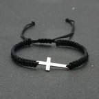 Pulsera de Cuerda con Cruz · Acero Inoxidable sobre superficie de madera — presentacion del producto