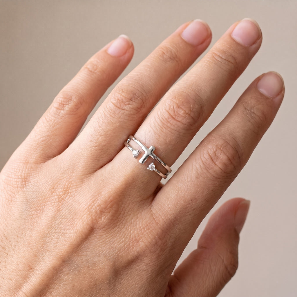 Anillo cruz con circonias plateado puesto en la mano