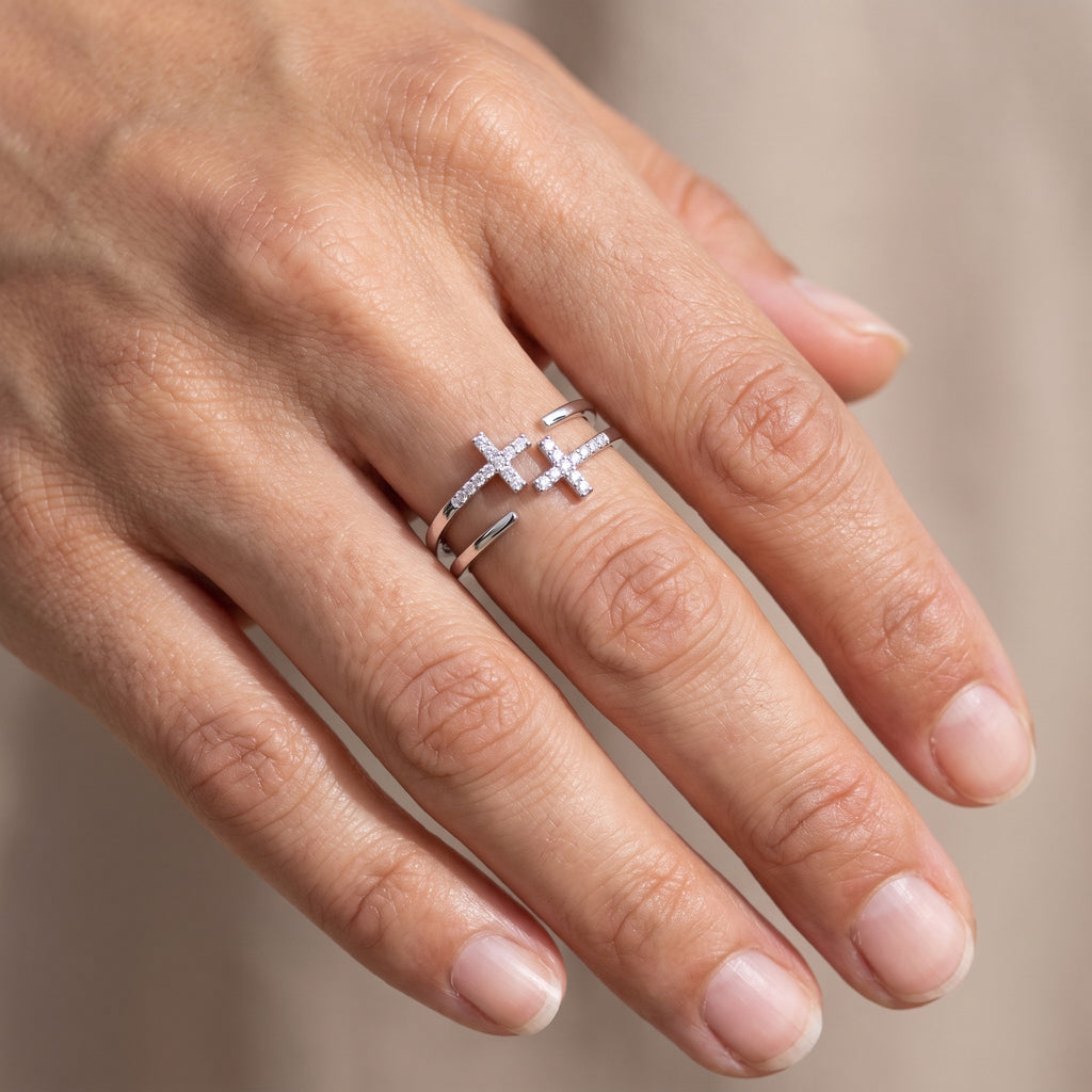 Anillo doble cruz de circonias plateado puesto en la mano
