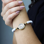 Mujer con la pulsera de San Benito en blanco en la muñeca — uso devocional
