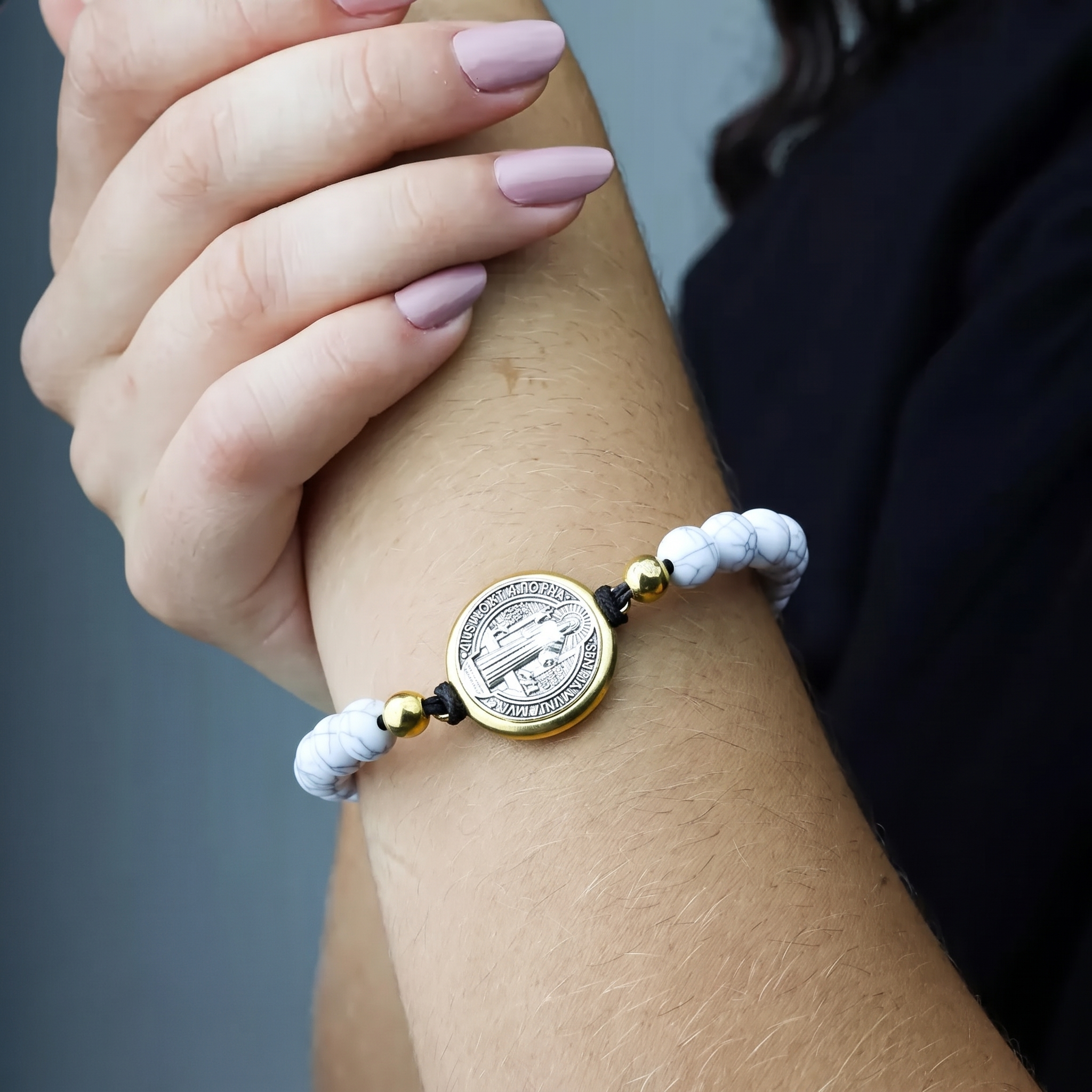 Mujer con la pulsera de San Benito en blanco en la muñeca — uso devocional