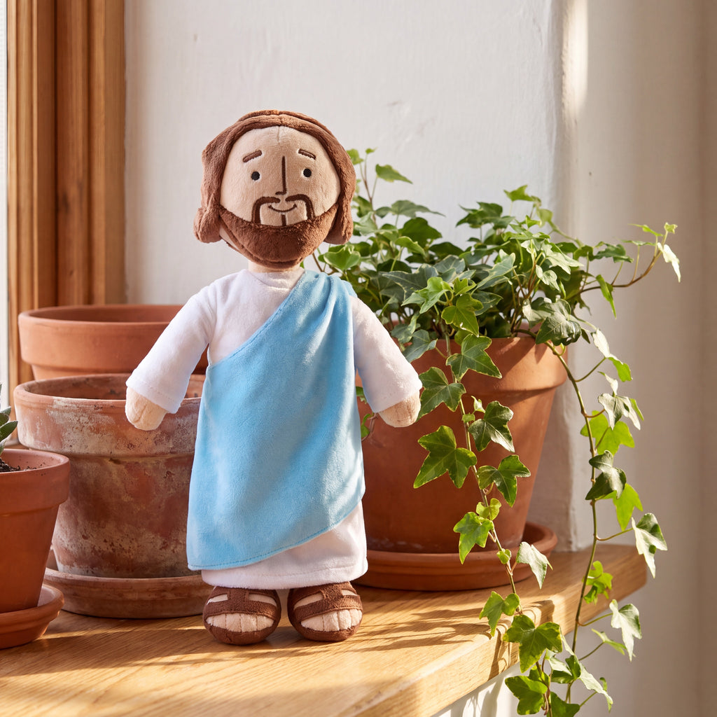 Peluche de Jesús junto a macetas de barro y hiedra en el hogar