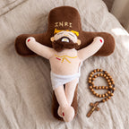 Cojín cruz de Cristo sobre la cama junto a un rosario de madera