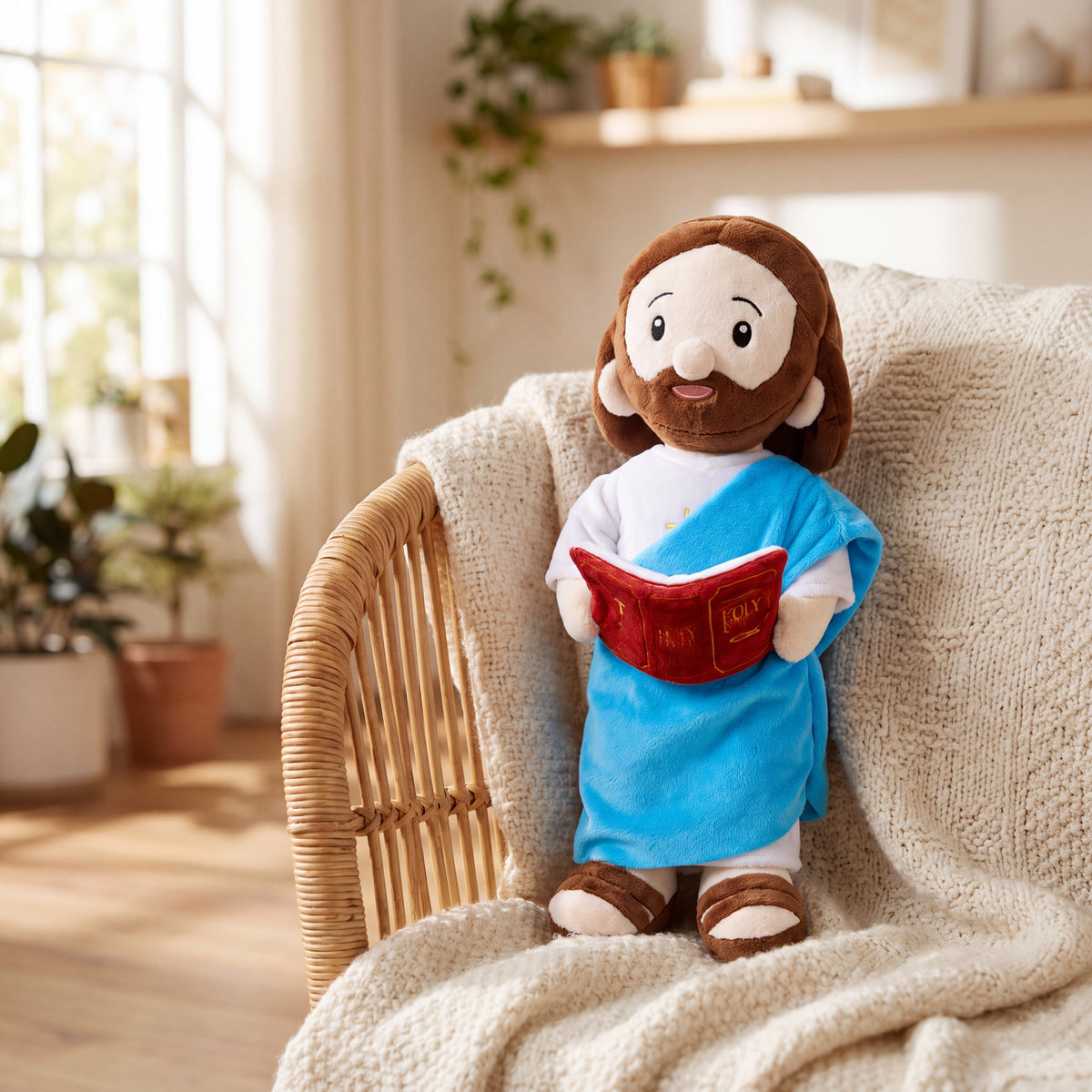 Peluche de Jesús con la Biblia apoyado en una silla de mimbre