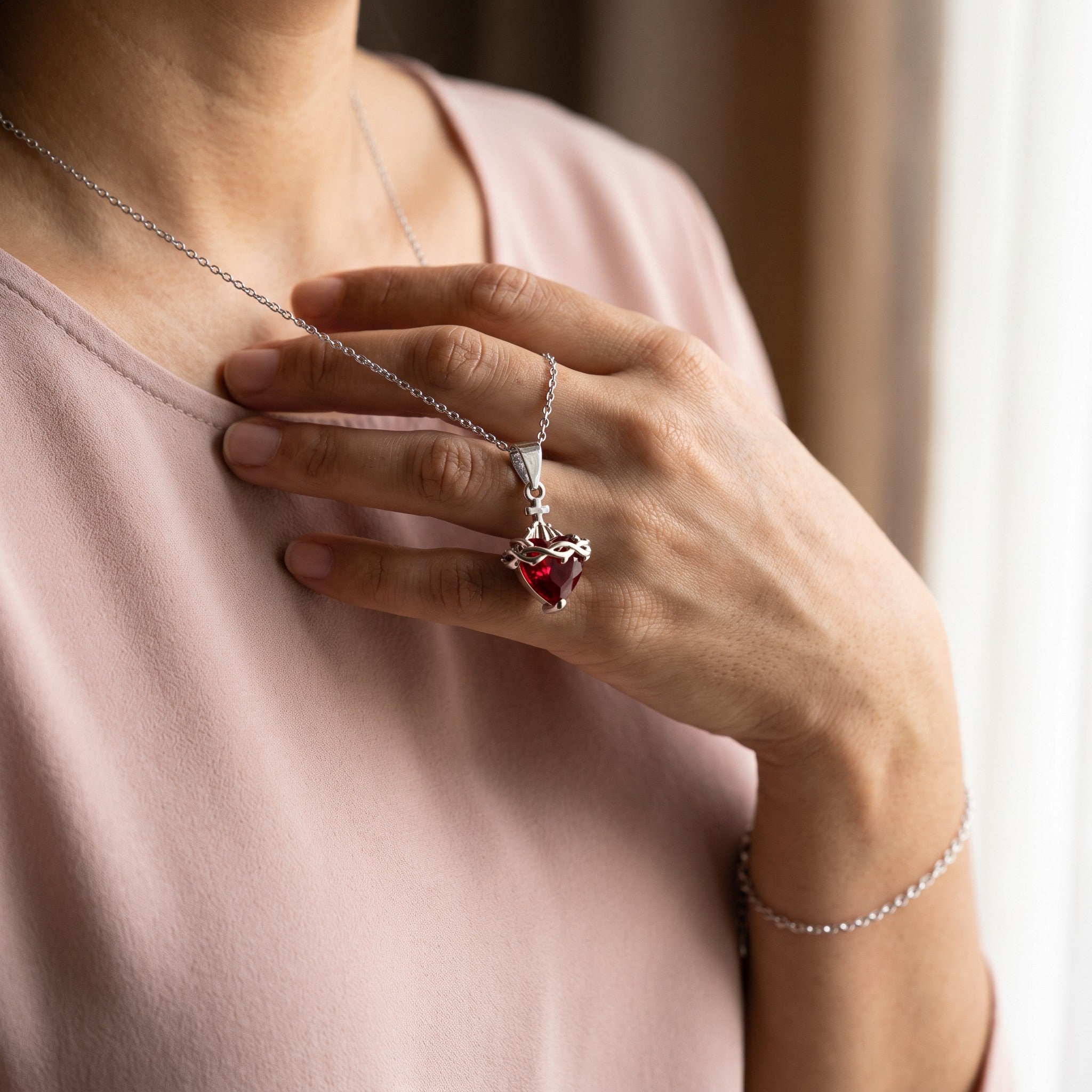 Colgante del Sagrado Corazón de Jesús en la mano, con pulsera a juego