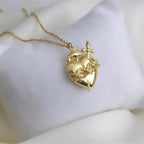 Detalle del colgante dorado del Inmaculado Corazón de María sobre tela