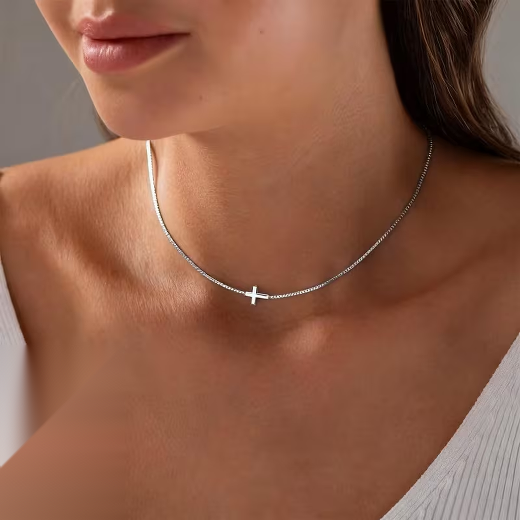 Collar de mini cruz horizontal en acero inoxidable plateado, puesto en el cuello
