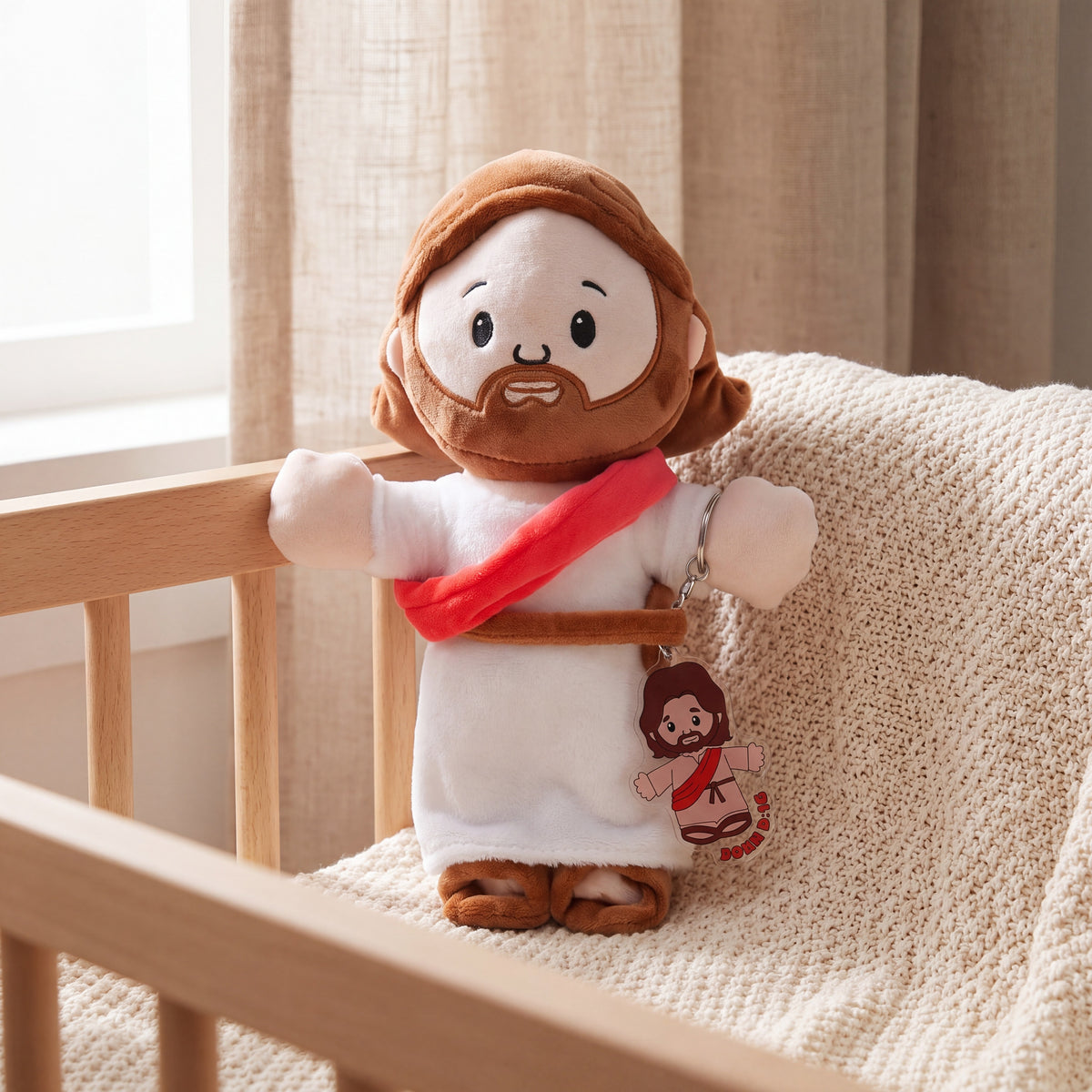 Peluche de Jesús con su llavero, recostado en una cuna de madera