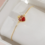 Detalle del Sagrado Corazón de Jesús en cristal rojo y baño dorado, presentado en su estuche de regalo