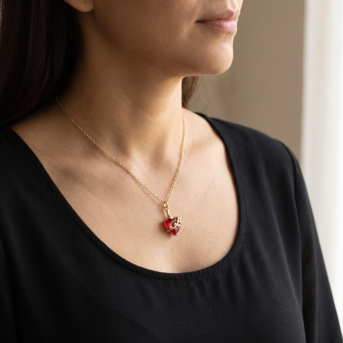 Mujer con el collar del Castísimo Corazón de San José puesto, colgante dorado sobre blusa negra