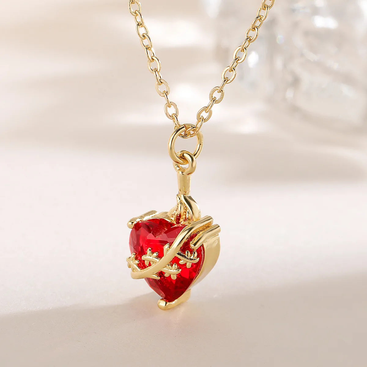 Detalle del colgante del Castísimo Corazón de San José: circonia roja facetada atravesada por la vara florecida